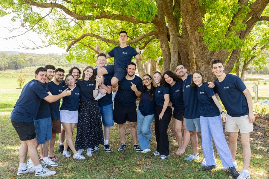 AUJS students posing together under a tree at a campus gathering